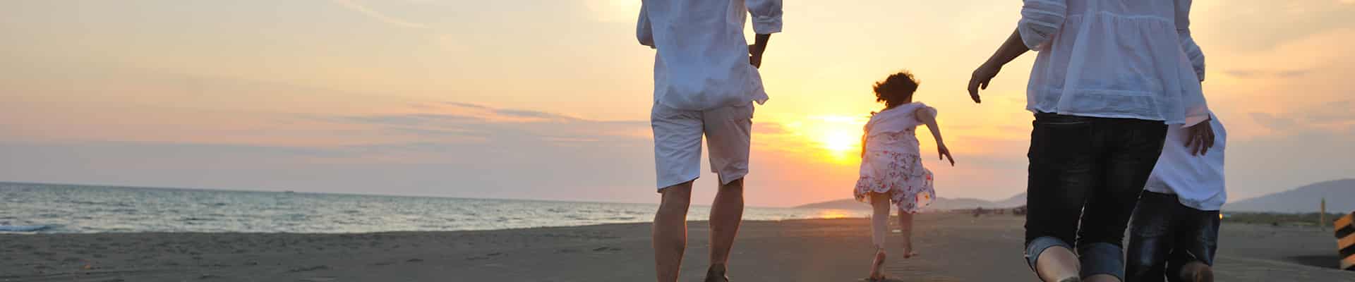 Family running on beach during sunset