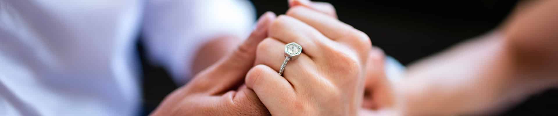 Couples hands embracing with ring